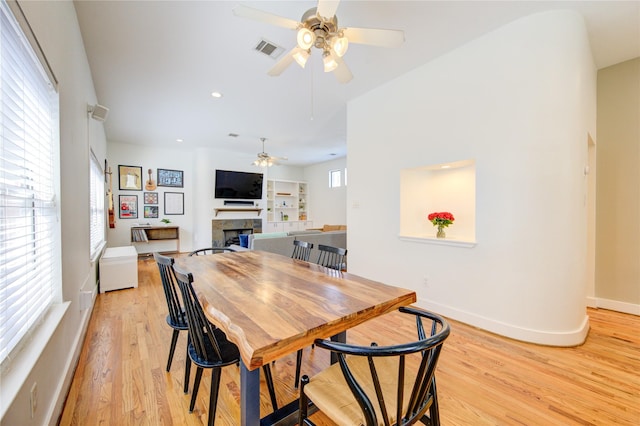 dining area with light wood-type flooring and ceiling fan