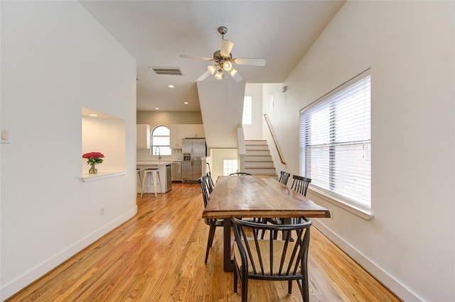 dining room featuring sink, ceiling fan, a wealth of natural light, and light hardwood / wood-style flooring