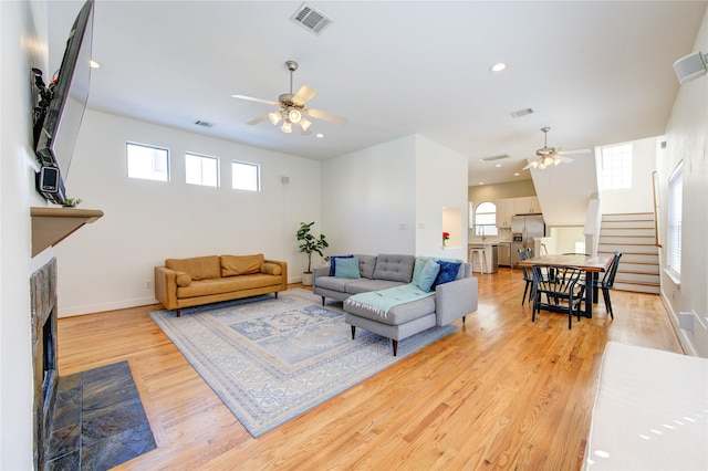 living room featuring ceiling fan and light hardwood / wood-style floors