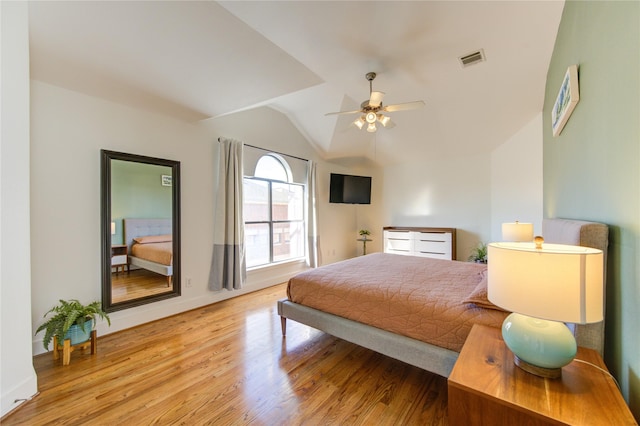 bedroom with ceiling fan, vaulted ceiling, and light hardwood / wood-style flooring