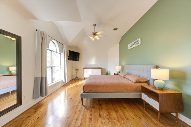 bedroom with lofted ceiling, ceiling fan, and light wood-type flooring