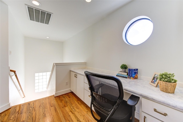 home office with light hardwood / wood-style flooring and plenty of natural light