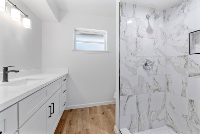 bathroom with vanity, wood-type flooring, and tiled shower