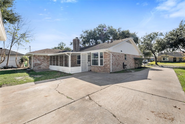 rear view of house with a yard and a sunroom