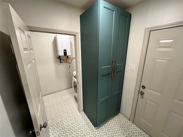 bathroom with tankless water heater and washer / clothes dryer