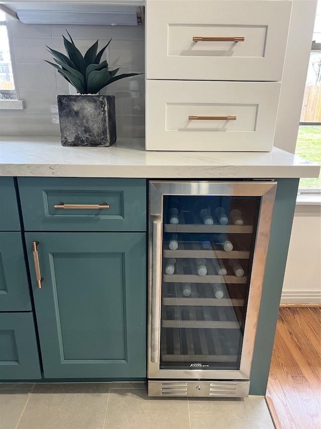 bar featuring white cabinets, light tile patterned floors, and beverage cooler