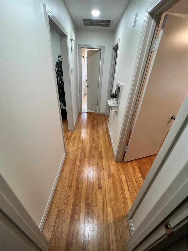 hallway with light hardwood / wood-style floors