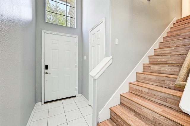 tiled entrance foyer featuring a high ceiling