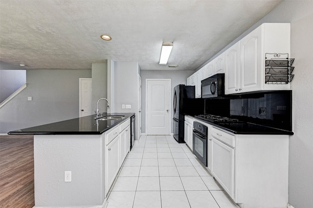 kitchen featuring sink, white cabinetry, light tile patterned floors, kitchen peninsula, and black appliances