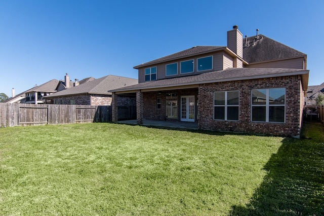 back of house featuring a yard, a patio, and french doors