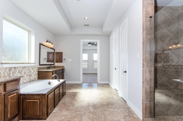 bathroom featuring vanity, ceiling fan, a raised ceiling, and independent shower and bath