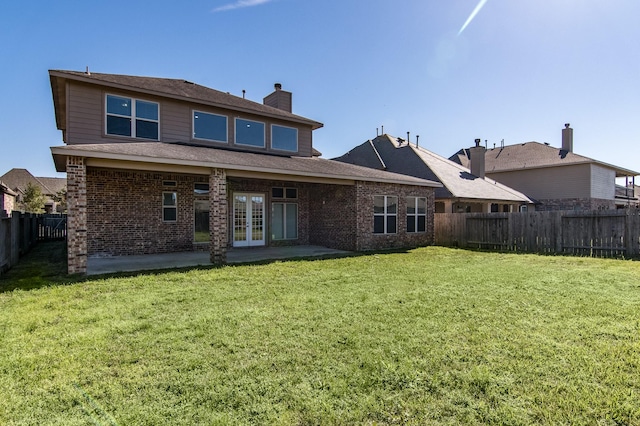 rear view of house with a yard, a patio, and french doors