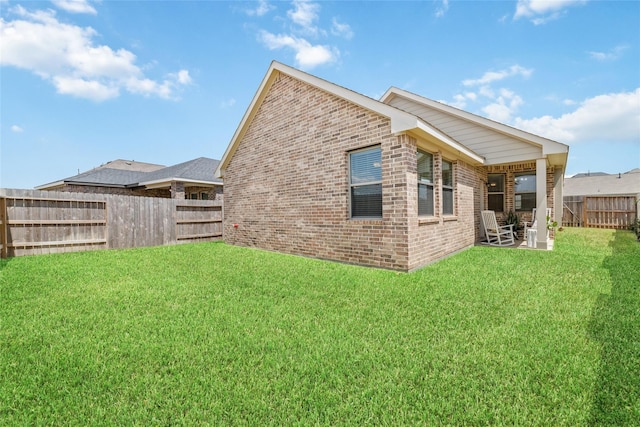 back of house with a yard and a patio