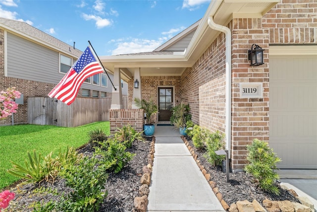 view of exterior entry featuring a lawn and a garage