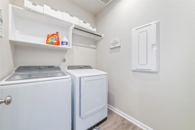 clothes washing area featuring hardwood / wood-style floors and washer and clothes dryer