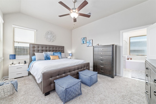 carpeted bedroom featuring ceiling fan, lofted ceiling, and ensuite bath