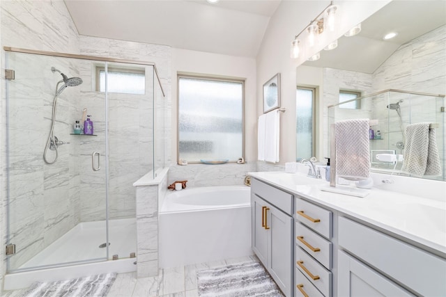 bathroom featuring a wealth of natural light, vanity, vaulted ceiling, and shower with separate bathtub