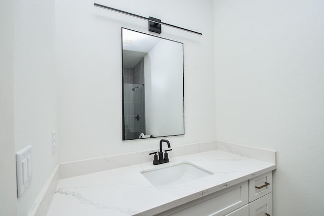 bathroom featuring a tile shower and vanity