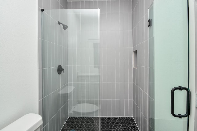 bathroom featuring toilet and an enclosed shower