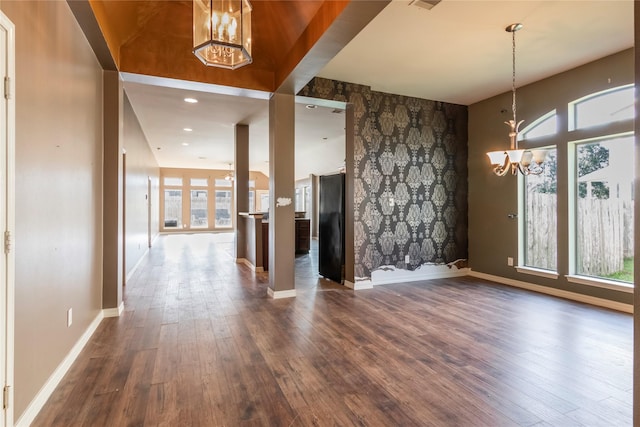 interior space with plenty of natural light, dark wood-type flooring, and a chandelier