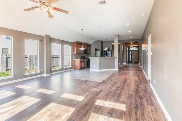 unfurnished living room with ceiling fan, a healthy amount of sunlight, lofted ceiling, and light hardwood / wood-style floors