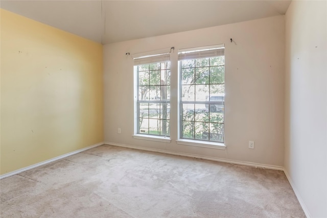 unfurnished room with light carpet and a wealth of natural light