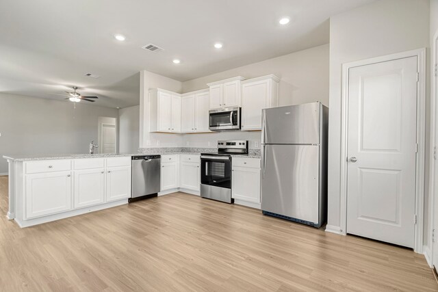 kitchen featuring white cabinetry, kitchen peninsula, and appliances with stainless steel finishes