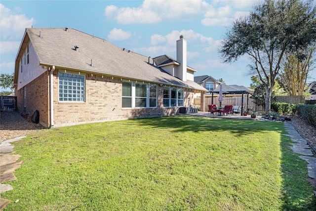 rear view of property featuring a lawn and a patio