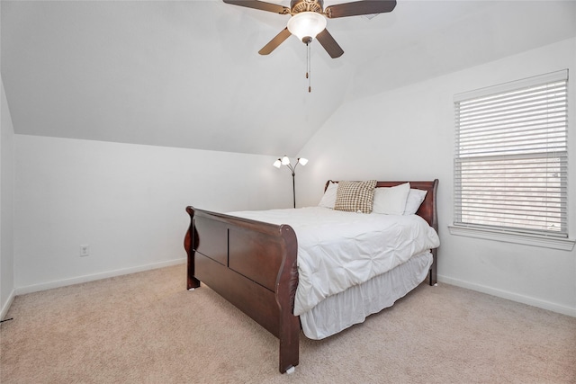 carpeted bedroom with ceiling fan and vaulted ceiling