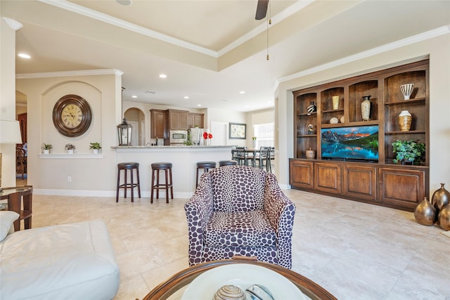 living room with ceiling fan, ornamental molding, and a tray ceiling