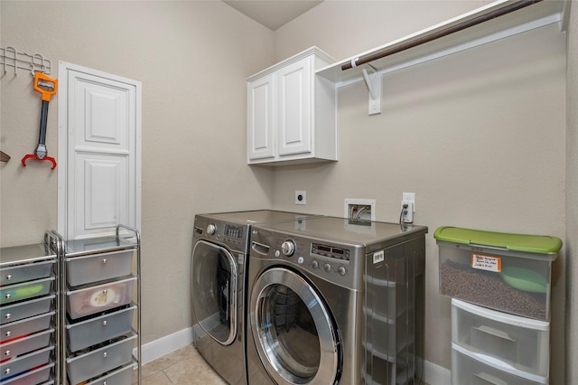 laundry room featuring light tile patterned flooring, cabinets, and independent washer and dryer