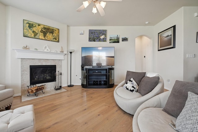 living room featuring a fireplace, hardwood / wood-style floors, and ceiling fan