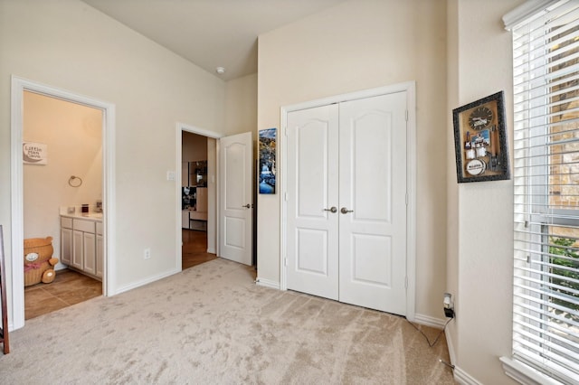 carpeted bedroom featuring connected bathroom and a closet