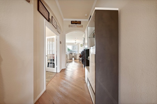 hall with light hardwood / wood-style floors and crown molding