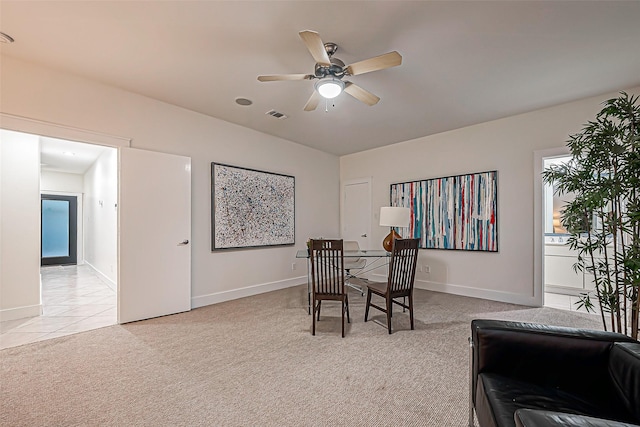 dining room with ceiling fan and light colored carpet