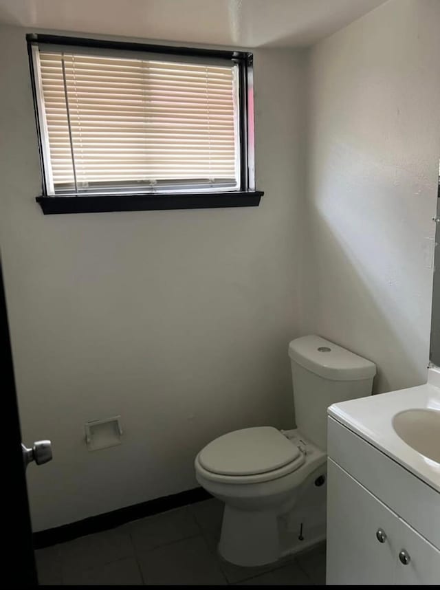 bathroom with tile patterned flooring, vanity, and toilet