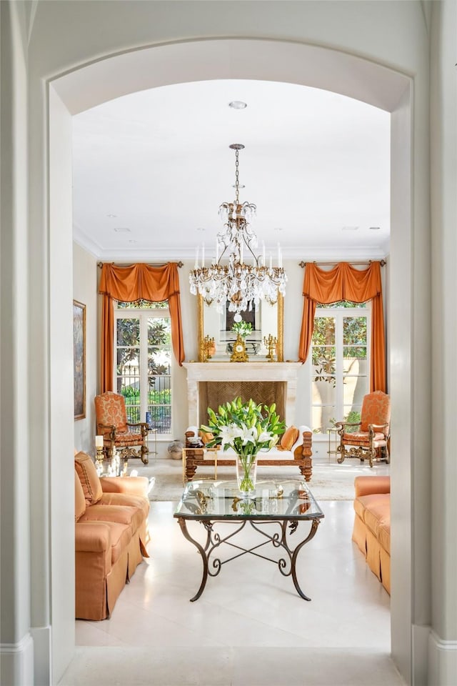 sitting room with a notable chandelier, ornamental molding, and a premium fireplace