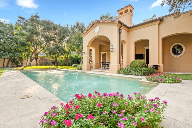 view of swimming pool with pool water feature and a patio