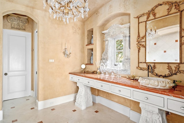 bathroom featuring tile patterned floors, vanity, built in features, and an inviting chandelier