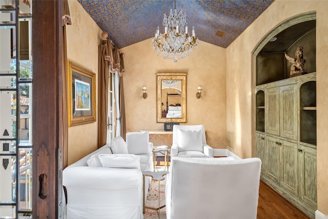 sitting room with wood-type flooring, vaulted ceiling, and a notable chandelier