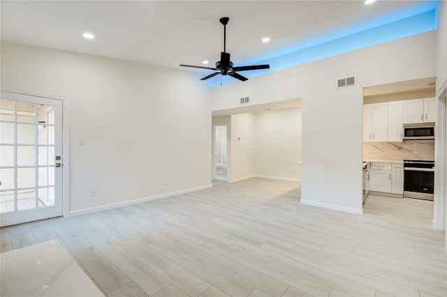 unfurnished living room with light wood-type flooring and ceiling fan