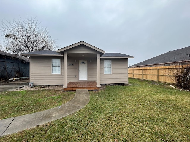 bungalow with a deck and a front lawn