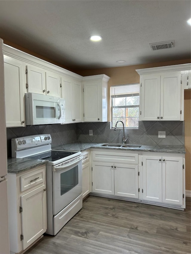 kitchen featuring sink, white cabinets, dark wood-type flooring, and white appliances