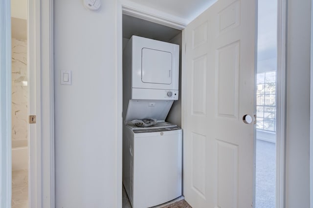 washroom with carpet and stacked washer / drying machine