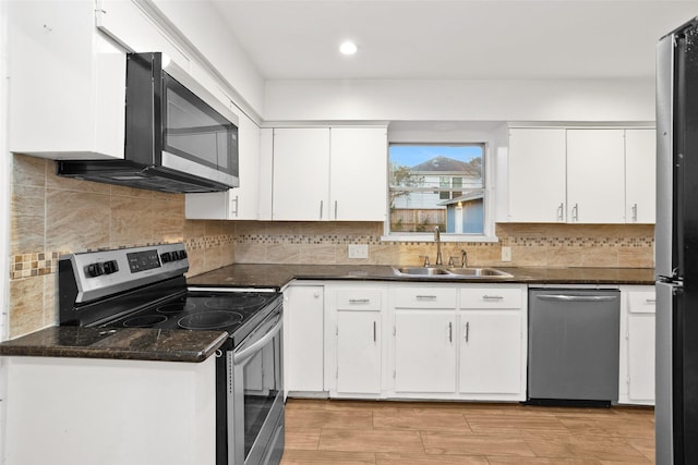 kitchen featuring white cabinets, appliances with stainless steel finishes, tasteful backsplash, and sink