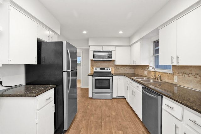 kitchen with sink, white cabinets, stainless steel appliances, and light hardwood / wood-style floors