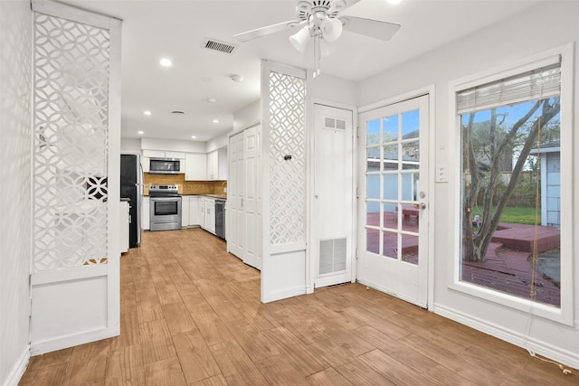 kitchen with white cabinets, stainless steel appliances, light hardwood / wood-style flooring, and ceiling fan