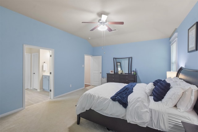 bedroom featuring light carpet, connected bathroom, vaulted ceiling, and ceiling fan