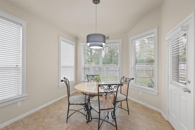 tiled dining space with vaulted ceiling