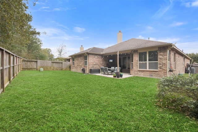 rear view of house with a patio and a lawn